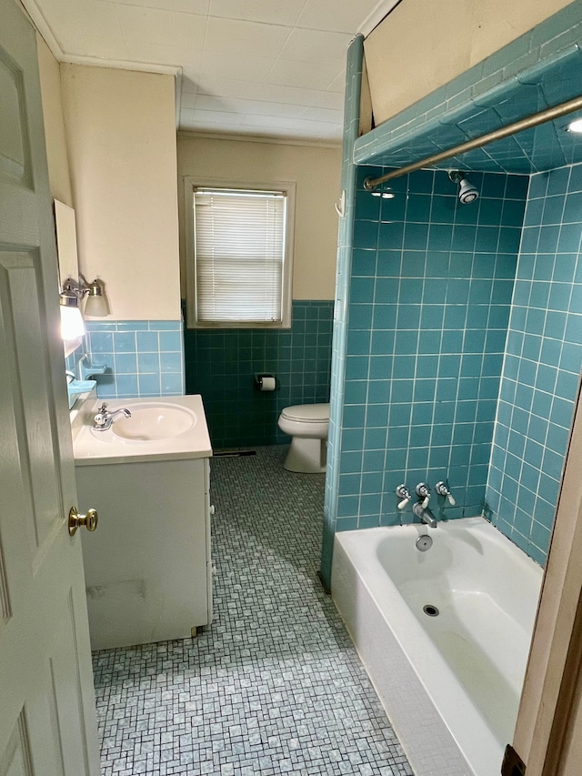 full bathroom with tile walls, toilet, vanity, and tile patterned flooring