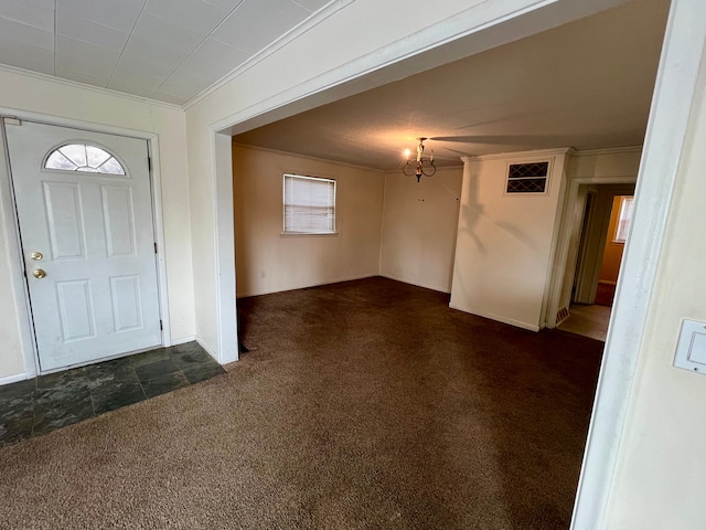 carpeted foyer entrance with a notable chandelier and ornamental molding