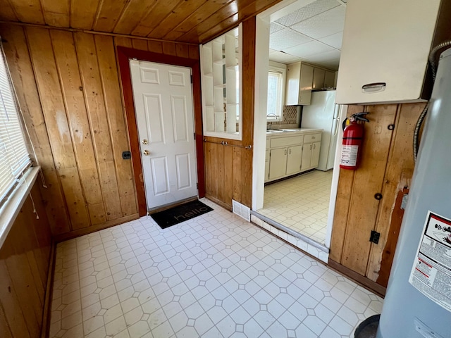 doorway featuring sink and wooden walls