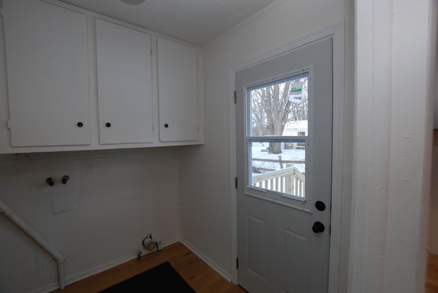 laundry area featuring hardwood / wood-style flooring and ornamental molding