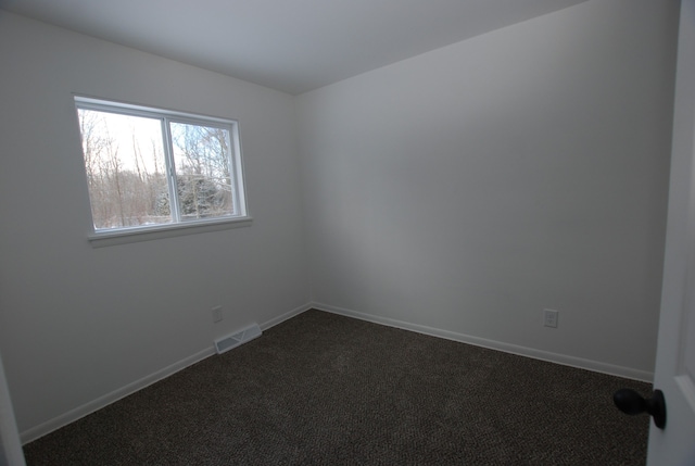 unfurnished room with dark carpet