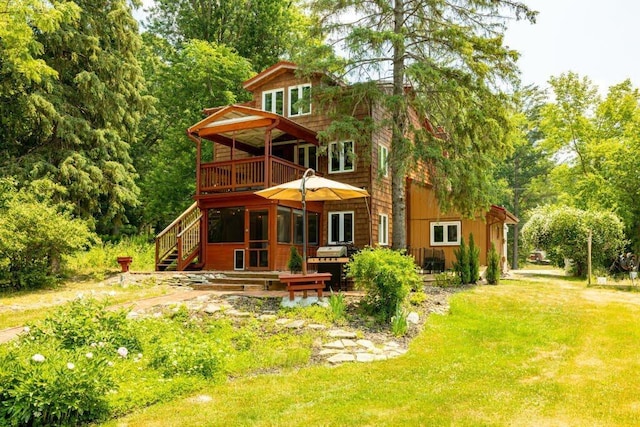 back of property featuring a lawn and a deck