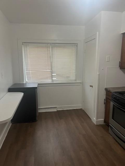 unfurnished dining area featuring dark wood-style floors and baseboard heating