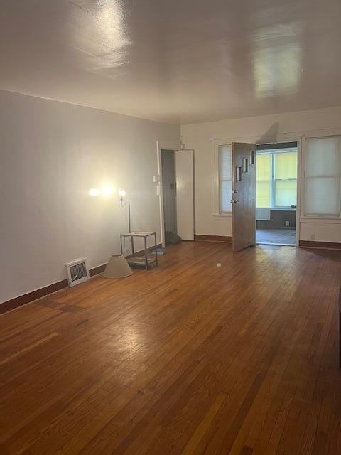 spare room featuring dark wood finished floors and baseboards