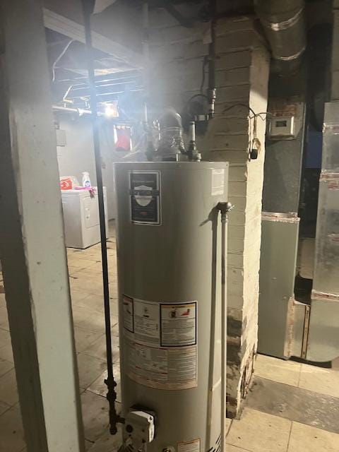 utility room with gas water heater, washer / dryer, and heating unit