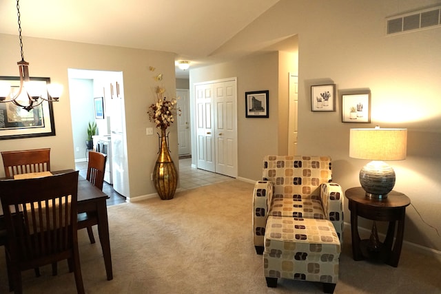 living area with light carpet, lofted ceiling, and a chandelier