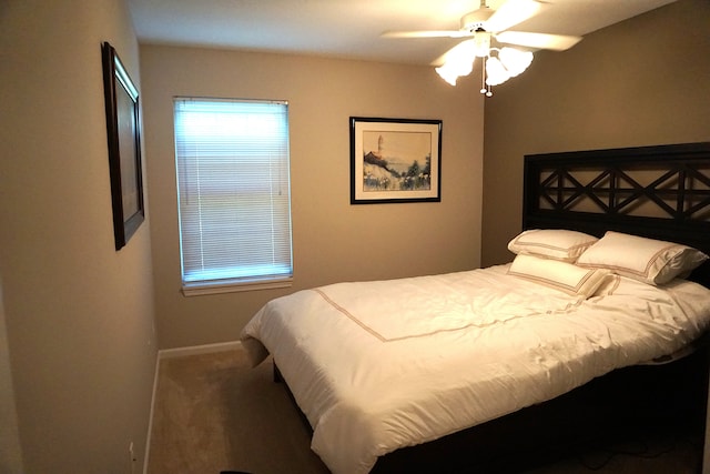 carpeted bedroom featuring baseboards, multiple windows, and ceiling fan