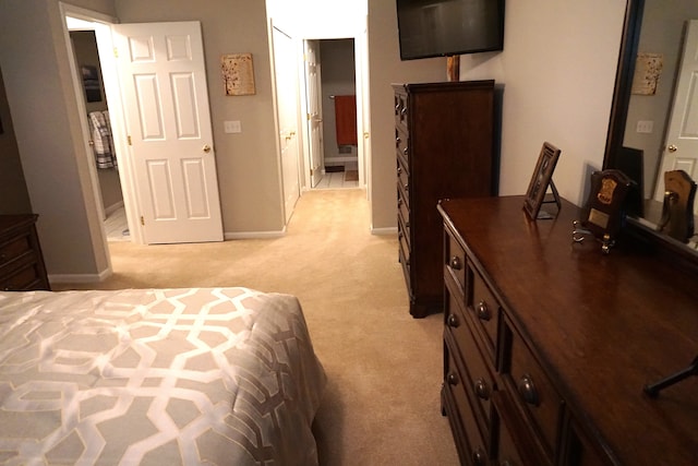 bedroom featuring light carpet and baseboards