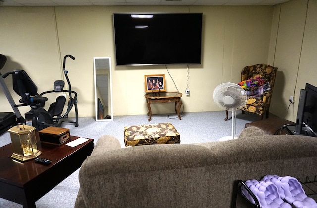 living area featuring carpet and a paneled ceiling