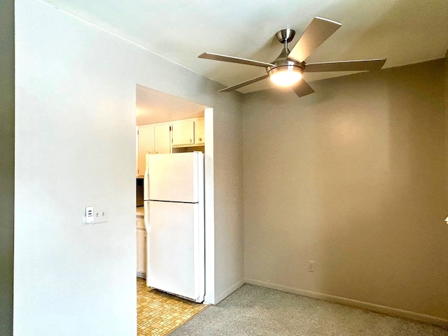 spare room featuring a ceiling fan and baseboards