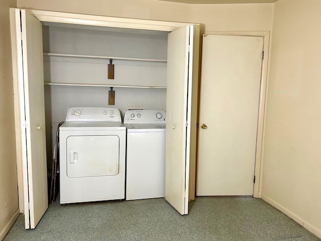 clothes washing area with laundry area, washing machine and dryer, and baseboards