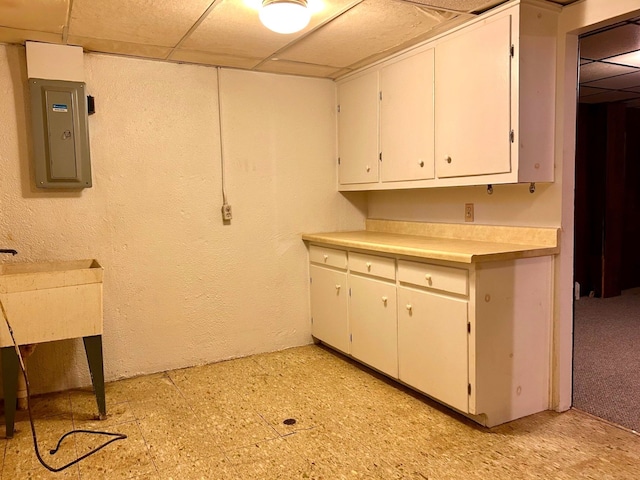 laundry area with electric panel and light floors