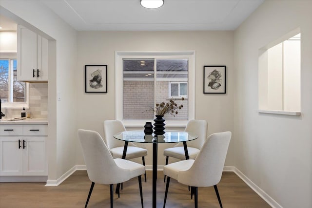 dining area with baseboards and wood finished floors