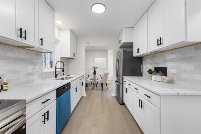 kitchen featuring light hardwood / wood-style floors, light stone countertops, white cabinetry, and stainless steel appliances