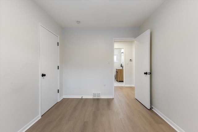 unfurnished bedroom with visible vents, baseboards, and light wood-style floors