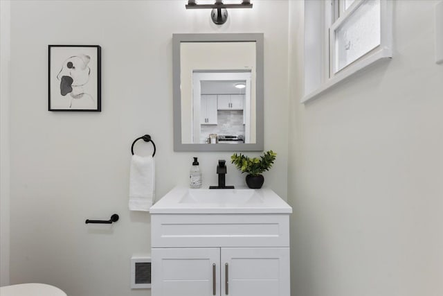 half bath with visible vents, toilet, and vanity