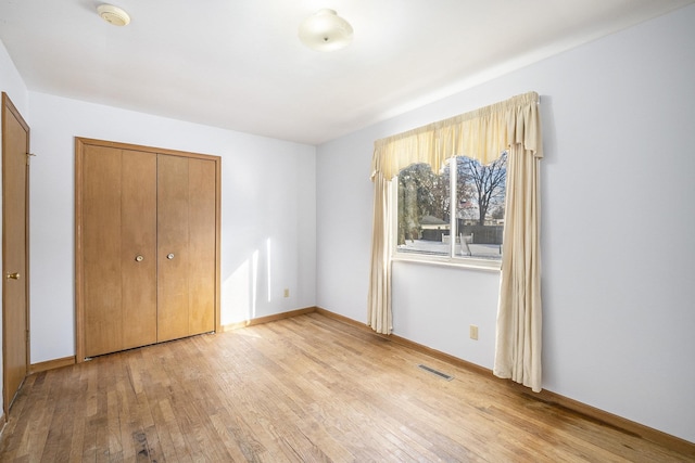 unfurnished bedroom featuring a closet and light hardwood / wood-style flooring