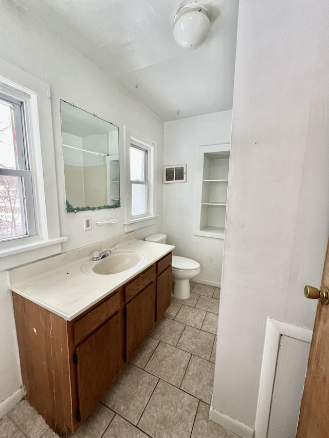 bathroom featuring toilet, plenty of natural light, and vanity