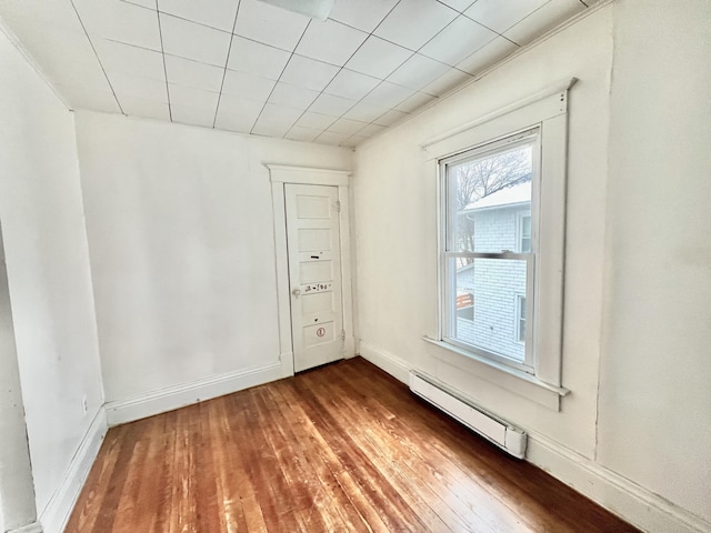 unfurnished room with dark hardwood / wood-style floors and a baseboard radiator