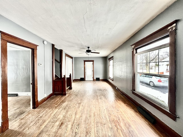 interior space with a textured ceiling, ceiling fan, and hardwood / wood-style flooring