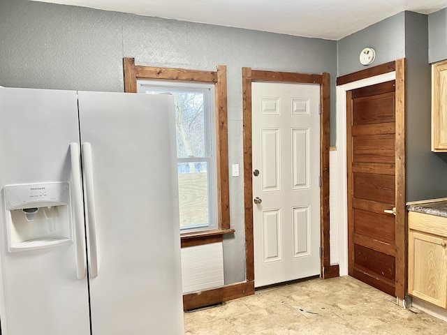 interior space featuring light brown cabinetry and white fridge with ice dispenser