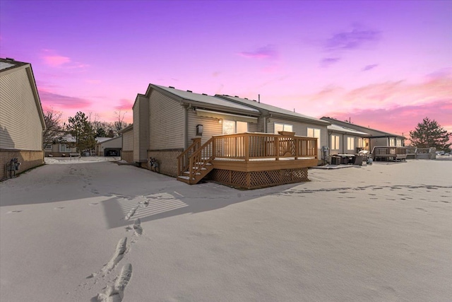 back house at dusk with a wooden deck