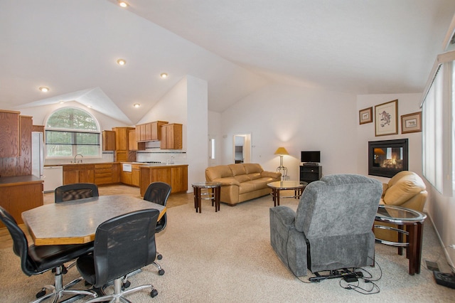 carpeted living room with a multi sided fireplace, lofted ceiling, and sink