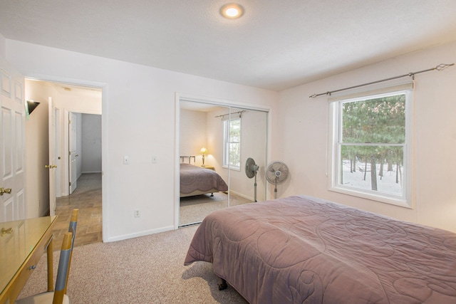 bedroom with light carpet and a closet