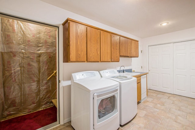 washroom with cabinets, separate washer and dryer, and sink