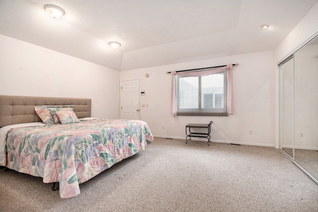 carpeted bedroom with lofted ceiling and a closet