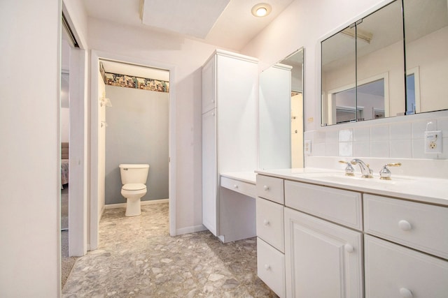 bathroom with tasteful backsplash, vanity, and toilet