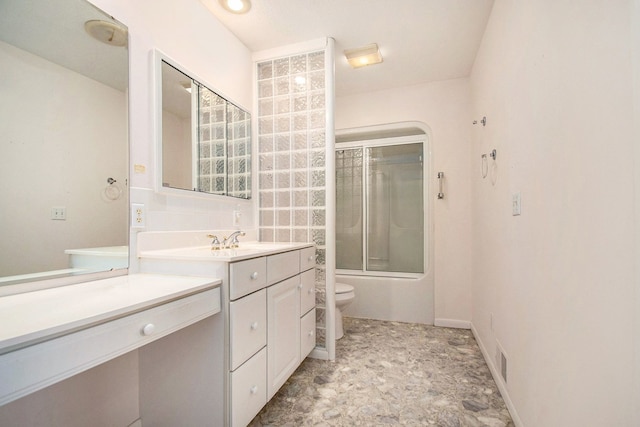 full bathroom featuring vanity, toilet, and combined bath / shower with glass door