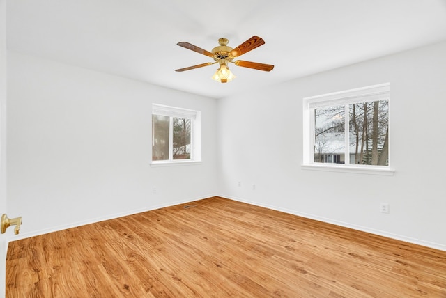 empty room with ceiling fan and light hardwood / wood-style floors