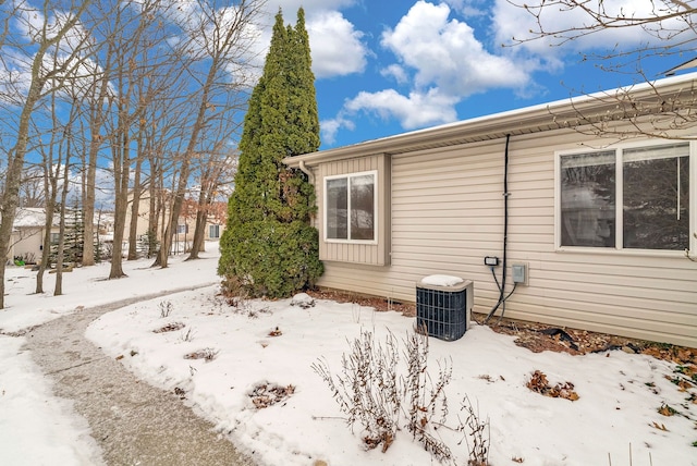 view of snowy exterior featuring cooling unit