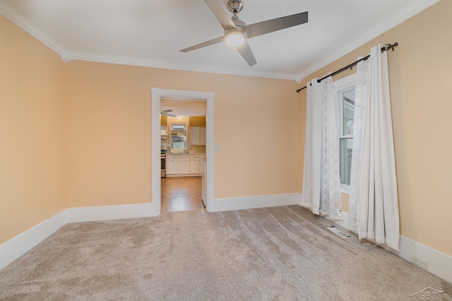 carpeted empty room featuring ceiling fan and ornamental molding