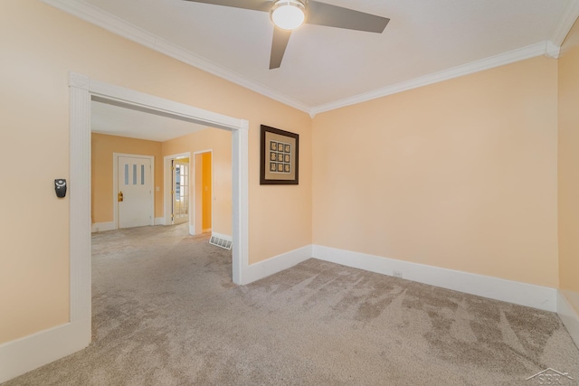 spare room featuring carpet floors, ceiling fan, and crown molding