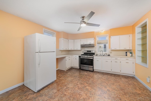 kitchen with a healthy amount of sunlight, stainless steel gas stove, white fridge, and white cabinetry