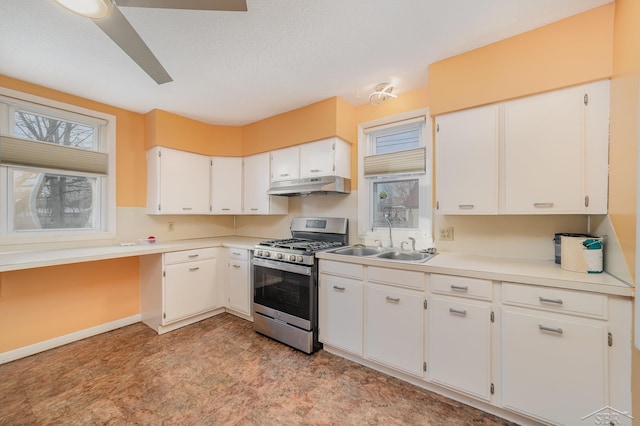 kitchen with white cabinetry, gas stove, and sink