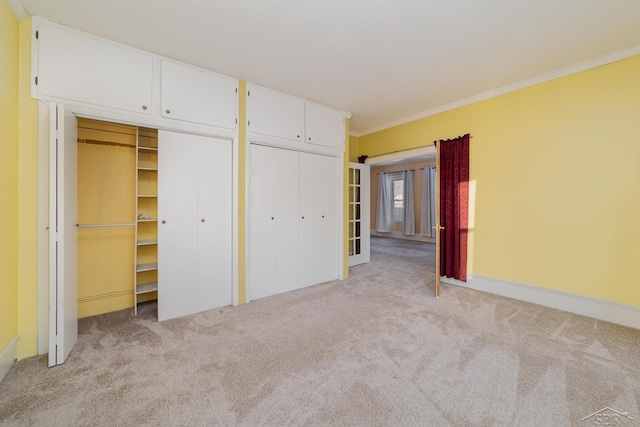 unfurnished bedroom featuring multiple closets, ornamental molding, and light colored carpet