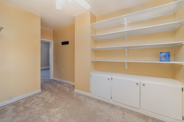 empty room featuring ceiling fan and light colored carpet