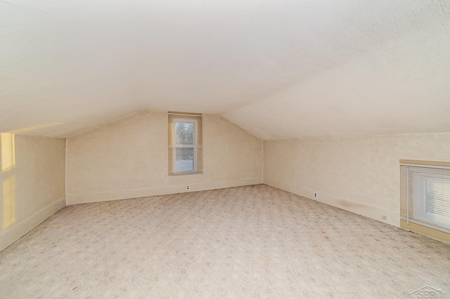 bonus room featuring lofted ceiling and carpet flooring