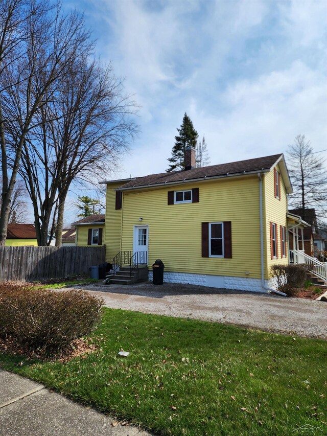 1454 Vermont St, Saginaw, MI 48602 - rear view of property with a chimney, fence, and a yard