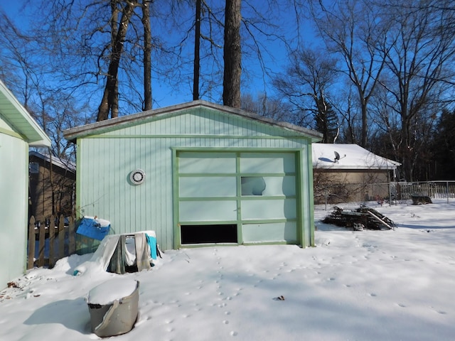 snow covered structure featuring a garage