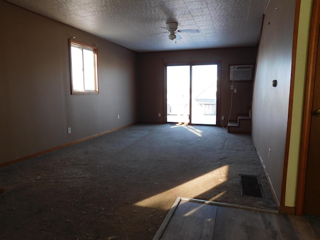 spare room featuring an AC wall unit and ceiling fan