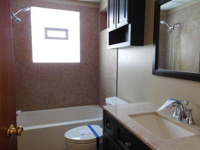 full bathroom with toilet, vanity, a wealth of natural light, and tiled shower / bath