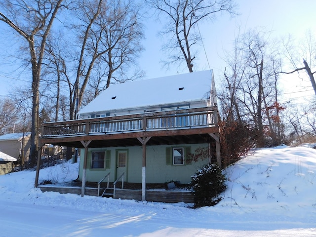 snow covered property with a wooden deck