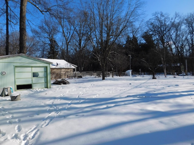 snowy yard featuring a garage