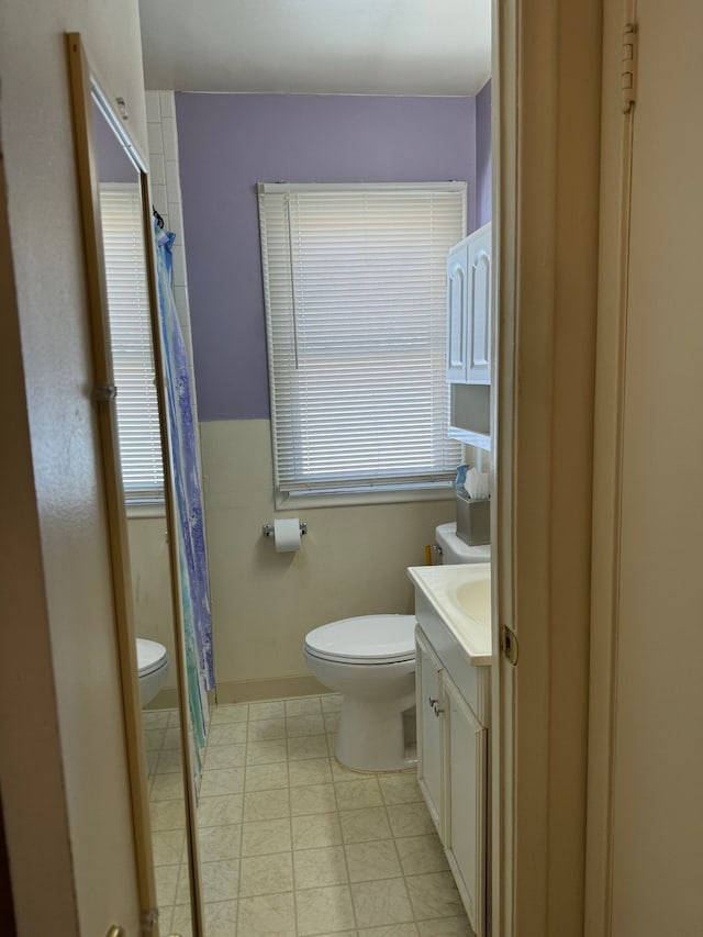 bathroom featuring toilet, vanity, and walk in shower