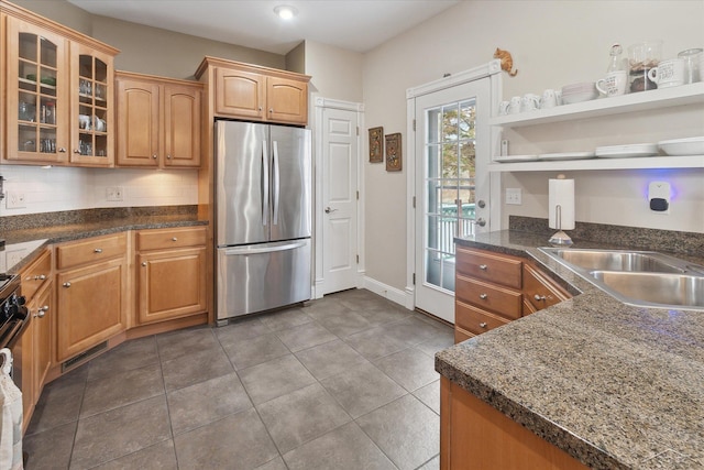 kitchen with decorative backsplash, stainless steel fridge, and sink