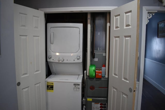 clothes washing area featuring stacked washer and clothes dryer